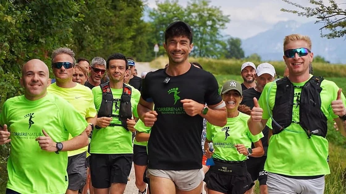 Un gruppo di runner con le magliette di Correre Naturale corre su uno sterrato, Daniele Vecchioni al centro